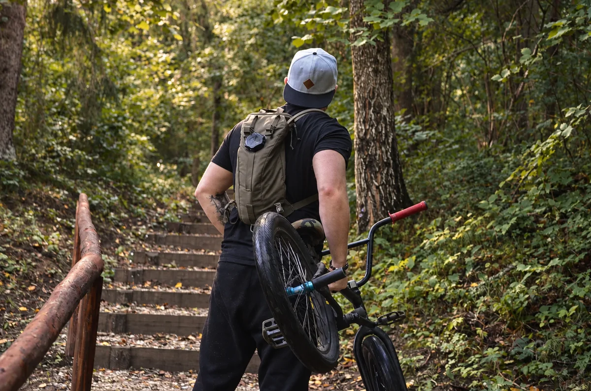 Cyclist carrying a bike up forest steps